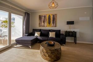 a living room with a couch and a table at Flower Beach Lanzarote in Playa Honda