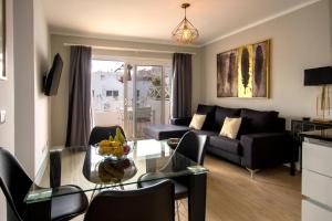 a living room with a couch and a glass table at Flower Beach Lanzarote in Playa Honda