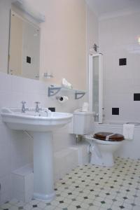 uma casa de banho branca com um lavatório e um WC em Bowood Park Hotel em Camelford