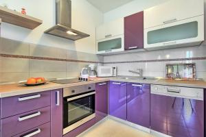 a kitchen with purple cabinets and a sink at SUMMERTIME house with apartment in Umag