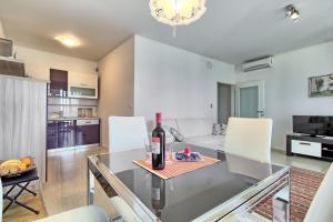 a kitchen with a glass table with a bottle of wine at SUMMERTIME house with apartment in Umag