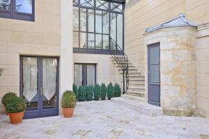 a building with potted plants in front of it at Villa Victor Louis - Bordeaux Centre in Bordeaux