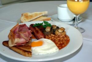 a plate of breakfast food with eggs bacon beans and toast at Bowood Park Hotel in Camelford