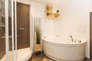 a white bathroom with a tub and a shower at Chill apartments in Prague