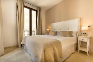 a bedroom with a large white bed with a window at Siloe Plaza in Granada