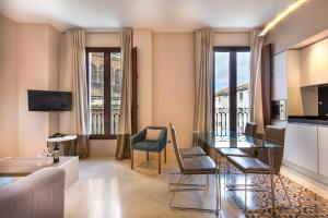 a living room with a table and chairs and a kitchen at Siloe Plaza in Granada