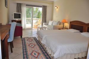 ein Schlafzimmer mit Bett, Schreibtisch und Fernseher in der Unterkunft Okaliptus Otel in Bitez