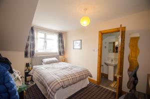 a bedroom with a bed and a sink at Knight's Rest Guest House in Airdrie
