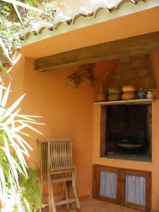 Casa Rural La Torreta في Corbera de Alcira: غرفة بها كرسي خشبي ورف