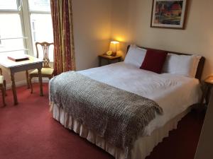 a bedroom with a bed and a table and a window at O'Donovan's Hotel in Clonakilty