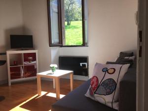 uma sala de estar com um sofá e uma mesa em A coté de Genève 2 em Saint-Cergues