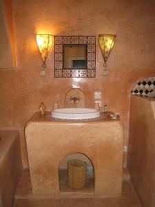 a bathroom with a tub and a sink with a mirror at Dar Loulema in Essaouira