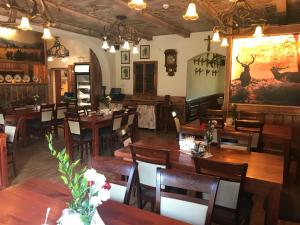 a restaurant with wooden tables and chairs and a painting on the wall at Podgórzanka in Kaczorów