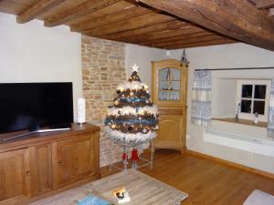 a christmas tree in a living room with a tv at Au Cocon d'Avoine in Hamois