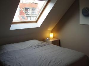 een slaapkamer met een bed en een raam bij Zonnig appartement in Nieuwpoort
