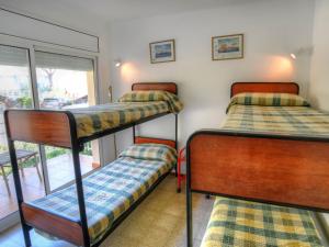 サン・フェリウ・デ・ギホルスにあるD27032 caocaの窓付きの客室で、二段ベッド3台が備わります。