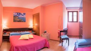 1 dormitorio con paredes de color naranja, 1 cama y 1 silla en Juliette Rooms, en Iesi