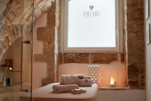 una camera da letto con un letto con finestra e candele di Iulius Suite & Spa a Conversano