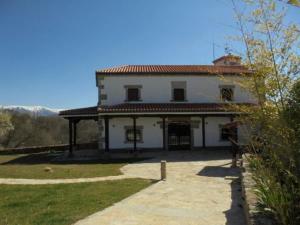 ein großes weißes Haus mit rotem Dach in der Unterkunft Casa Rural la Iglesuela in El Barco de Ávila
