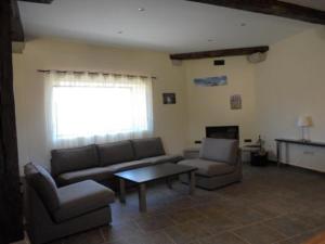 エル・バルコ・デ・アビラにあるCasa Rural la Iglesuelaのリビングルーム(ソファ、椅子、テーブル付)