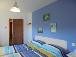 a blue bedroom with a bed with blue walls at Casa Rural la Iglesuela in El Barco de Ávila