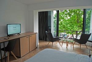 a hotel room with a television and chairs and a room at Prime Hotel in Tirana
