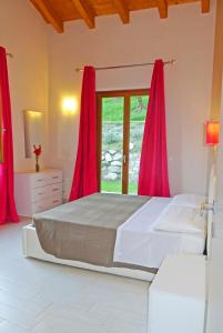 a bedroom with a large bed with red curtains at Appartamenti Villa Vagne by Gardadomusmea in Tremosine Sul Garda