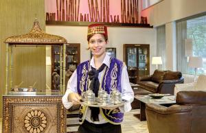 una mujer está sosteniendo una bandeja de botellas de agua en Susuzlu Atlantis Hotel, en Izmir