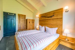 sypialnia z dużym łóżkiem z drewnianym zagłówkiem w obiekcie Waldsiedlung w mieście Kröpelin