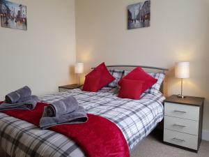 - une chambre avec un lit et des oreillers rouges dans l'établissement Charlotte Street 2 Bedroom Apartment, à Ayr
