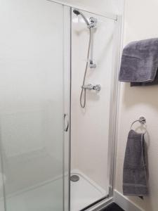 La salle de bains est pourvue d'une douche avec une porte en verre. dans l'établissement Charlotte Street 2 Bedroom Apartment, à Ayr