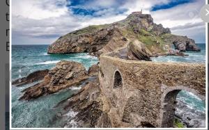 most nad oceanem z latarnią morską na górze w obiekcie Apartamentos-Bermeo w mieście Bermeo