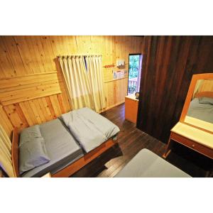 a bedroom with two beds in a wooden room at ABC Chalet Tioman in Tioman Island