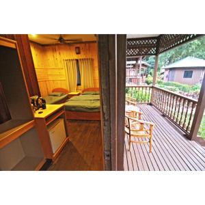 a room with a deck with a bedroom and a bed at ABC Chalet Tioman in Tioman Island