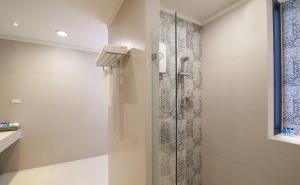 un bagno con doccia con porta in vetro di Sabai Sabai Sukhothai - SHA PLUS a Ban Khlong Krachong
