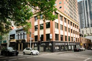 a white car parked in front of a building at Melbourne City Backpackers in Melbourne