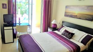 une chambre avec un lit et un bureau avec une télévision dans l'établissement Golden Beach II, à Jávea 23 autres photos