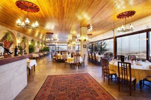 a dining room with tables and chairs and windows at Uchisar Kaya Otel in Uçhisar