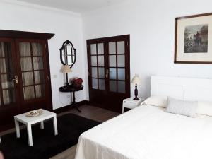 sypialnia z białym łóżkiem i stołem w obiekcie La Chimenea Verde w mieście Tacoronte