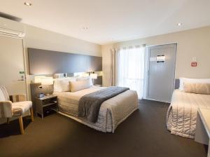 Ein Bett oder Betten in einem Zimmer der Unterkunft Airport Gateway Motor Lodge