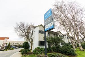 una señal azul frente a un edificio en Airport Gateway Motor Lodge en Christchurch