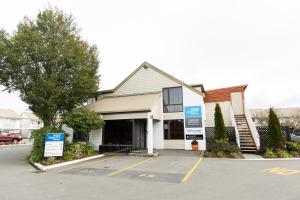 une maison avec un panneau dans un parking dans l'établissement Airport Gateway Motor Lodge, à Christchurch