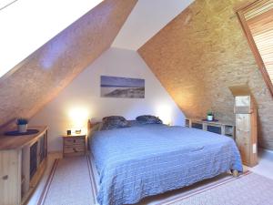 レリクにあるCozy Seaside Apartment in Rerik on Baltic Coastのベッドルーム1室(屋根裏部屋に青いベッド1台付)