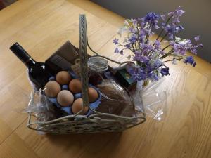a basket of eggs and a bottle of wine and flowers at Willow Cottage in Bognor Regis
