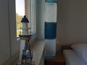 a room with a bed and a window with stacks of cups at Schwalbennest in Ueckeritz