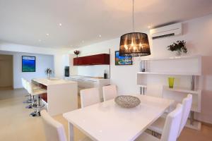 a kitchen and dining room with a white table and chairs at Villa Summer Dreams Apartments in Murter