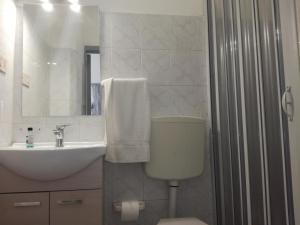 bagno con servizi igienici, lavandino e specchio di casa vacanze Sole & Mare a Giardini Naxos