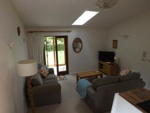 a living room with two couches and a television at Willow Cottage in Bognor Regis