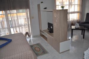 a living room with a couch and a tv at Sun & Sol in Caleta De Fuste