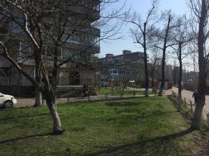 a park with trees and a building in the background at ARTAL Apartment on Iordanskaya 22 in Kyiv